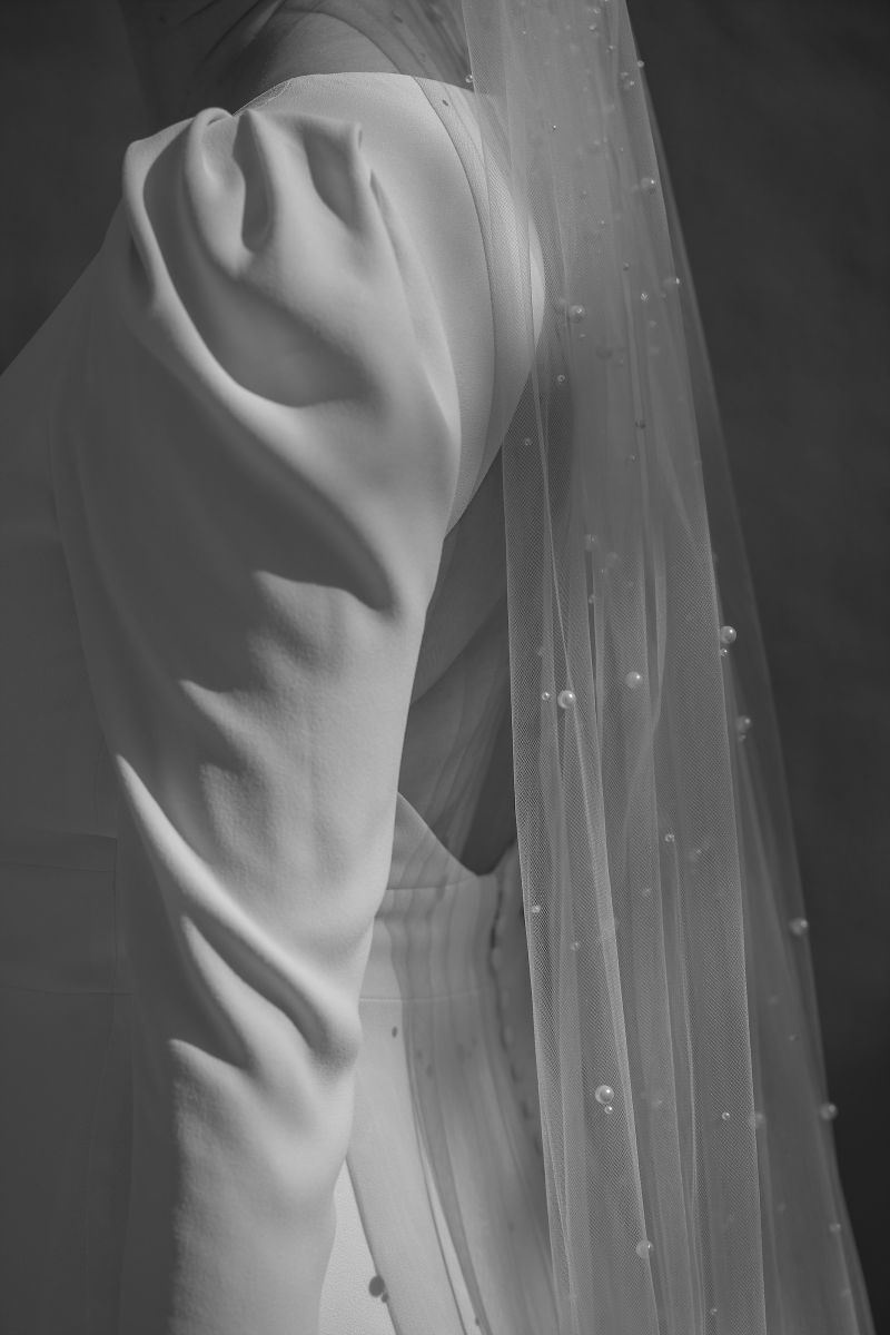 Nahaufnahme eines Brautkleid-Ärmels mit feinem Stoff im Licht